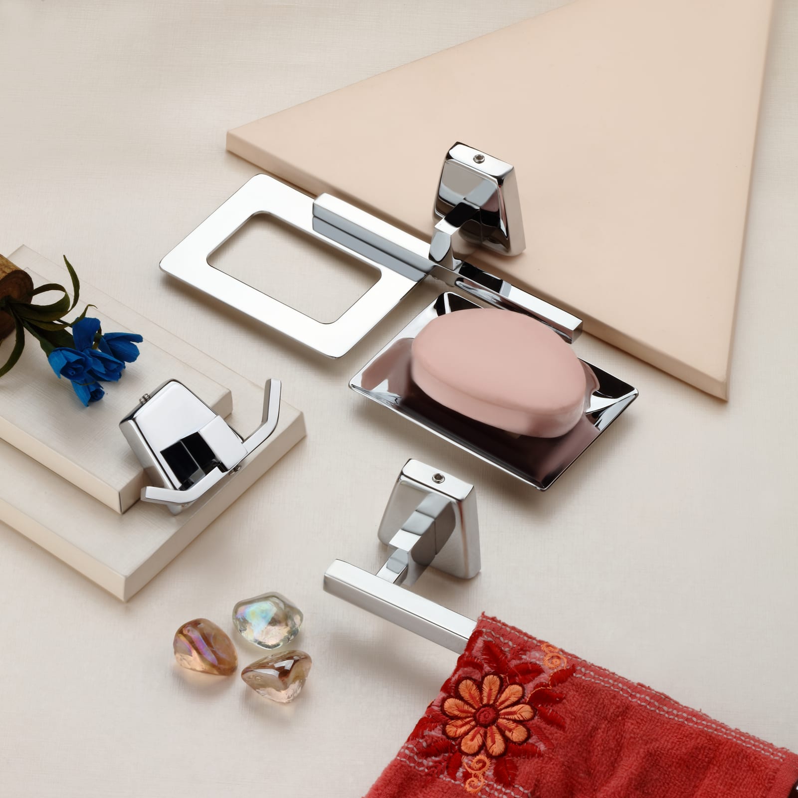 Curio series paper holder, robe hook and soap dish arranged on ivory tiles with a blush soap